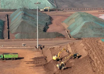 Los trabajadores operan maquinaria en un depósito de hierro en Rugao/AFP