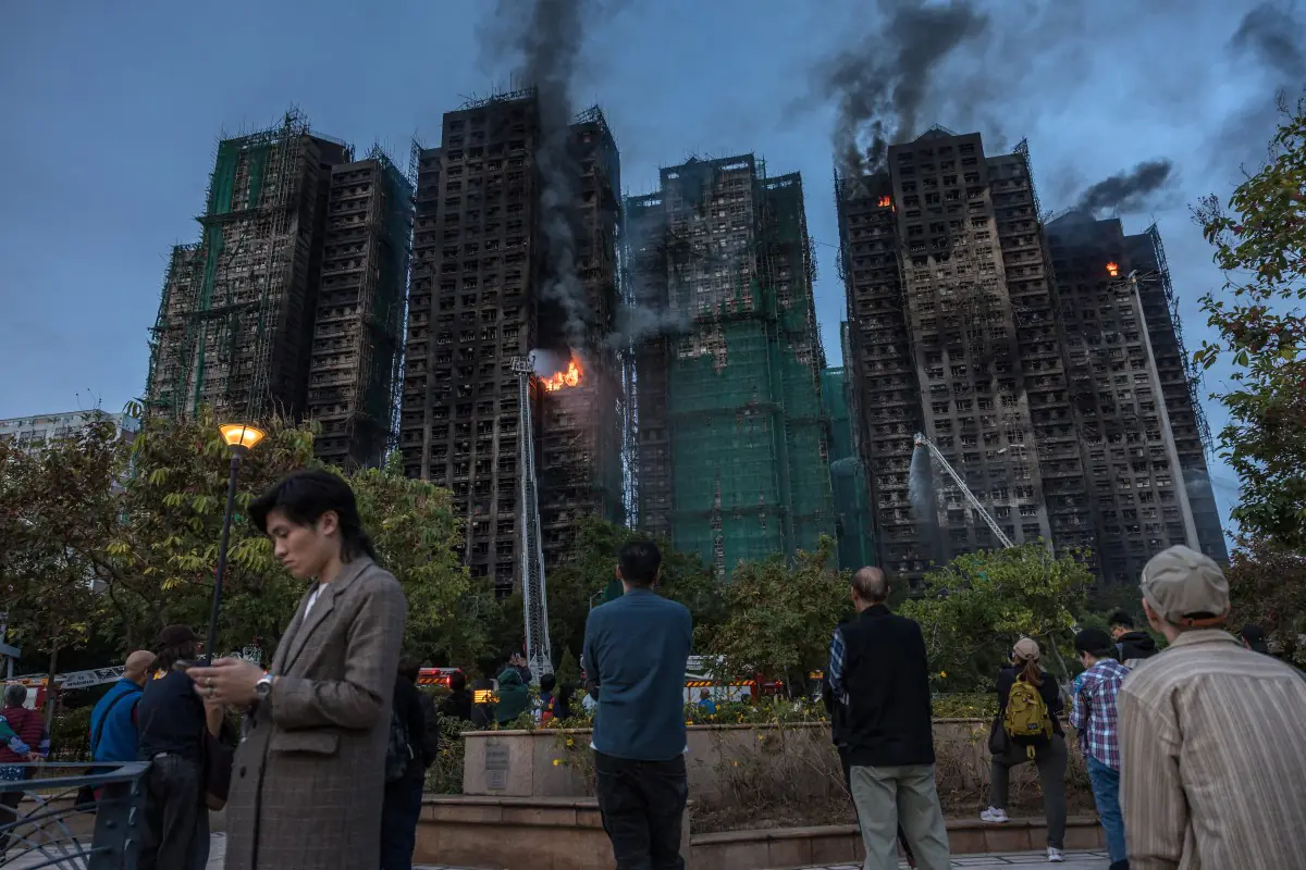 La gente observa cómo el humo se eleva del complejo habitacional/AFP