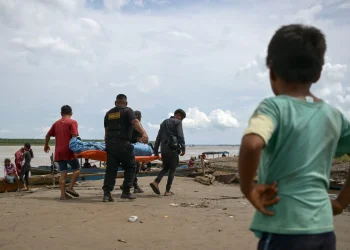 Oficiales de policía y lugareños cargan el cuerpo de una de las víctimas/AFP